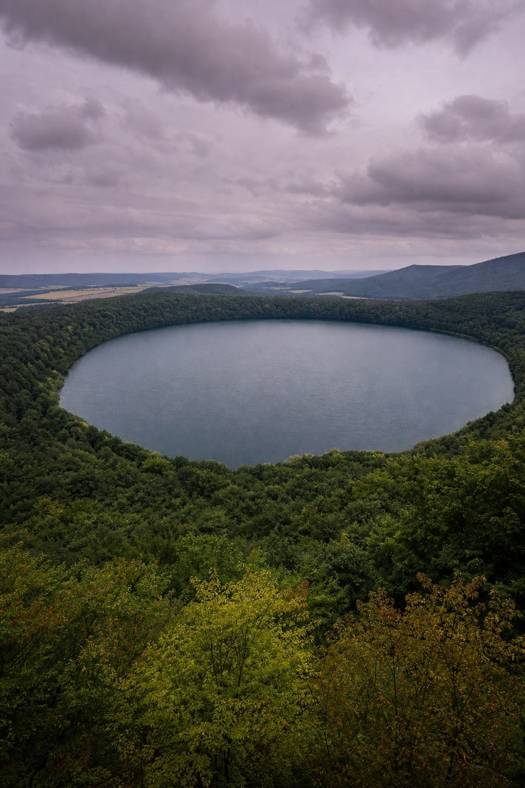 Runder Kratersee mit Waldsaum in der Vulkaneifel